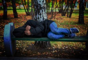 Homeless teen sleeping on a bench